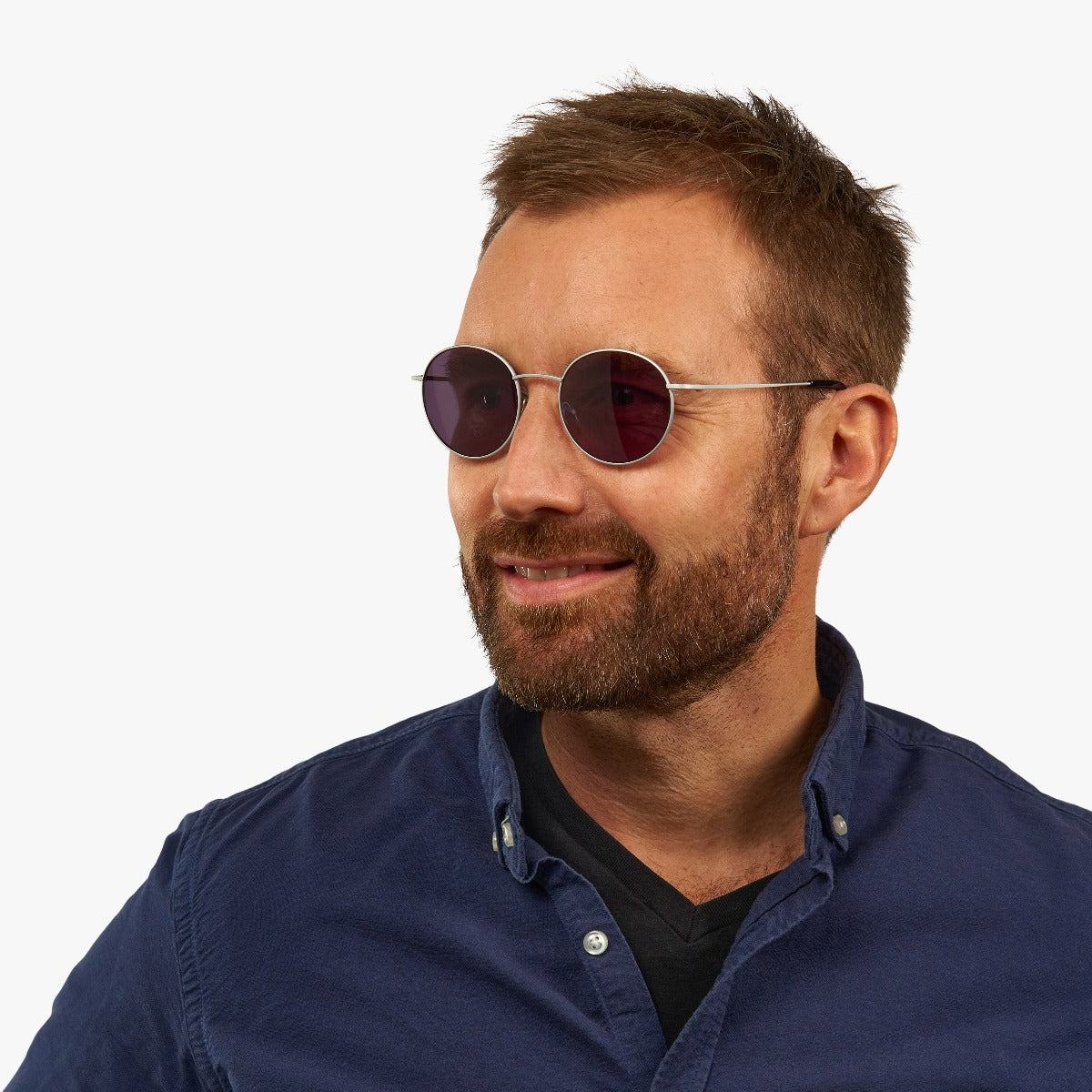 Person wearing round steel sunglasses with dark lenses