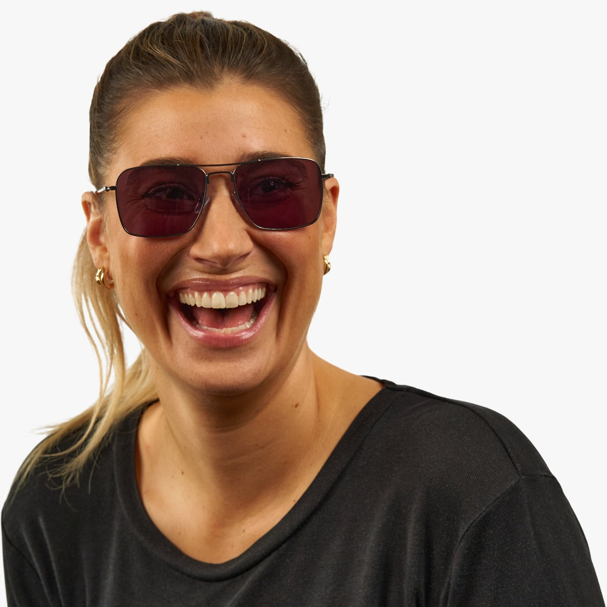 Person wearing square sunglasses with dark lenses and gold frames